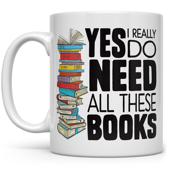 White mug that says Yes, I really do need all these books with a stack of books