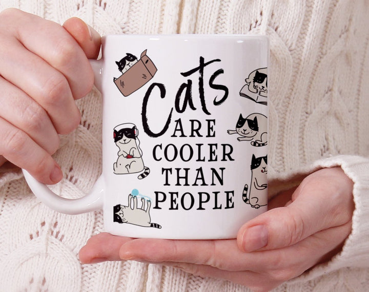 Cats Are Cooler Than People Mug held by hands