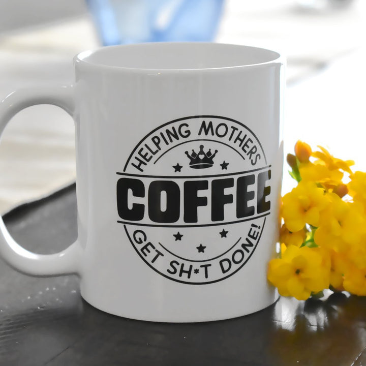 Coffee...Helping Mothers Get Sh*t Done! Mug on a counter next to flowers - Loftipop