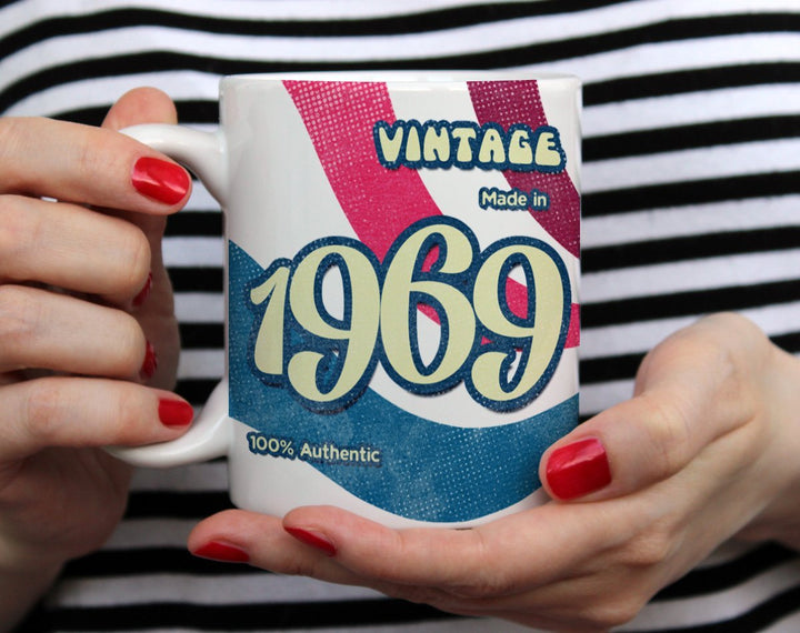 Custom Birth Year 1960's Retro Vintage Coffee Mug being held by woman wearing black and white top with red nail polish