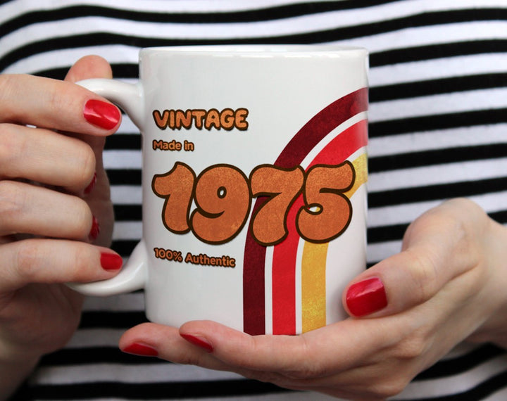 Custom Birth Year 1970's Retro Vintage being held by woman wearing black and white top with red nail polish Coffee Mug