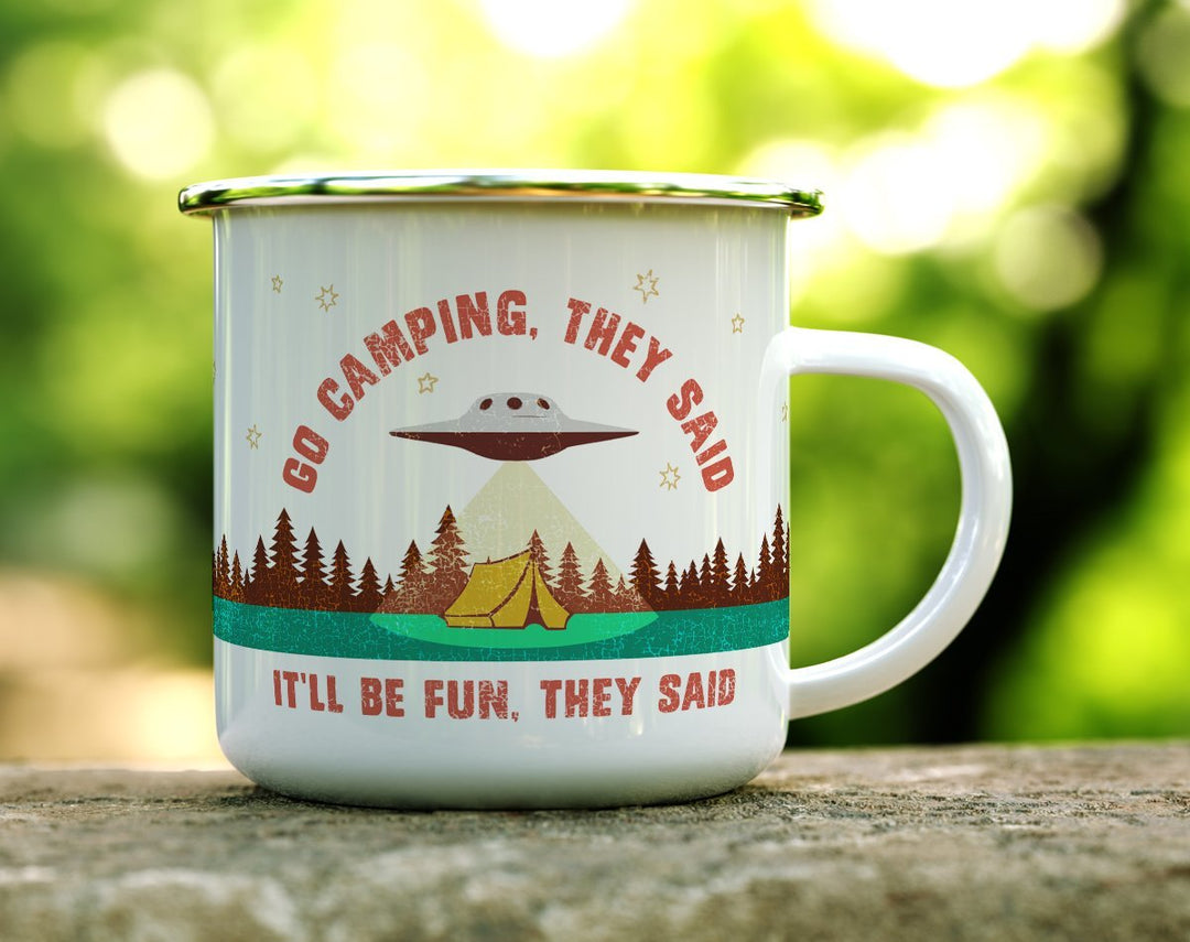 Camp mug that says Go Camping with an UFO over a tent in the woods on a log