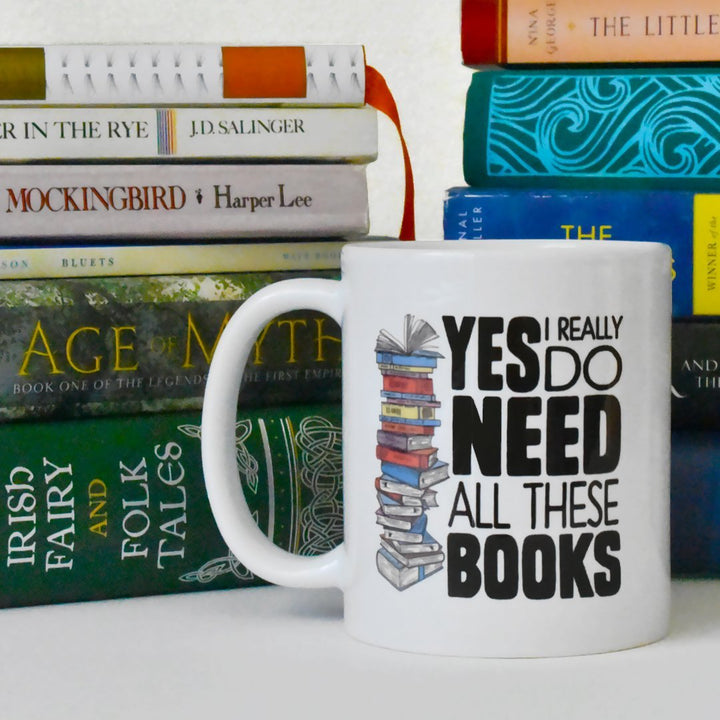 Yes I Really Do Need All These Books Mug next to a stack of books - Loftipop